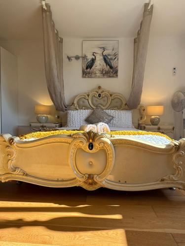 a bedroom with a gold bed with two birds on it at Barnfields Retreat in Little Clacton