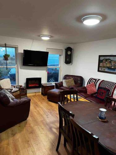 a living room with a couch and a table at River View - Modern 4 Bedroom Bungalow in Cabraghkeel