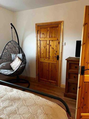 a bedroom with a swing chair and a dresser at River View - Modern 4 Bedroom Bungalow in Cabraghkeel