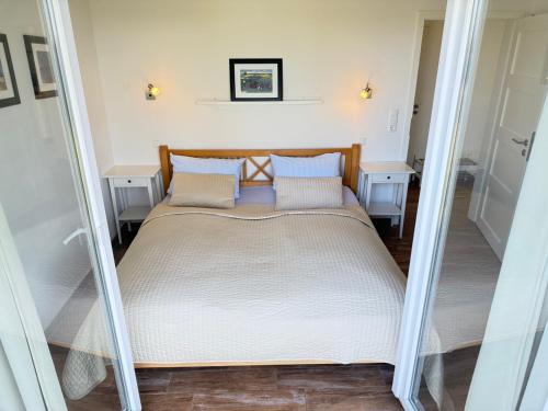 a large bed in a room with two tables at Schlei Resort Marina Hülsen in Kosel