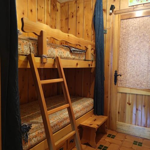 una stanza con due letti a castello e una scala di Sun & Relaxation La Tour a Morgex