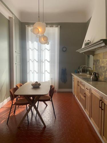 une cuisine avec une table et des chaises dans une pièce dans l'établissement Vue mer exceptionnelle dans château, à Sausset-les-Pins
