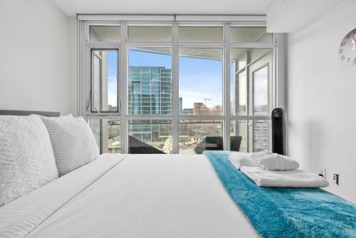 a bedroom with a white bed with a large window at Apartment in Downtown Toronto in Toronto