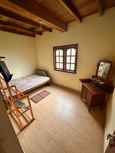 a room with a bed and a desk and a chair at Pears Villa Resort Haputale in Ginigatgala