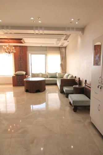 a large living room with a couch and a table at 3 Appartements Vue sur Mer dans une maison indépendante in Tangier