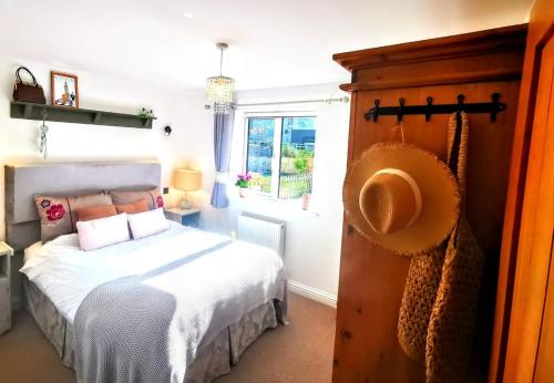a bedroom with a bed and a window at Cozy Cotswold getaway near Burford in Shilton