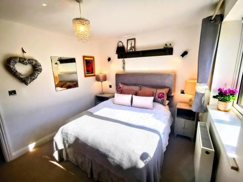 a bedroom with a bed and a mirror at Cozy Cotswold getaway near Burford in Shilton