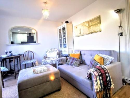 a living room with a couch and a chair at Cozy Cotswold getaway near Burford in Shilton