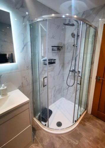 a shower with a glass enclosure in a bathroom at Cozy Cotswold getaway near Burford in Shilton