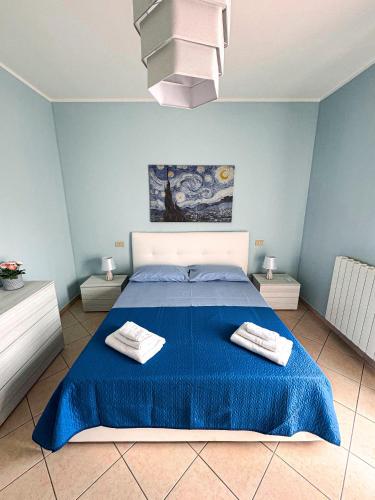 a blue bedroom with a bed with two towels on it at Appartamento Trinacria in Castellammare del Golfo