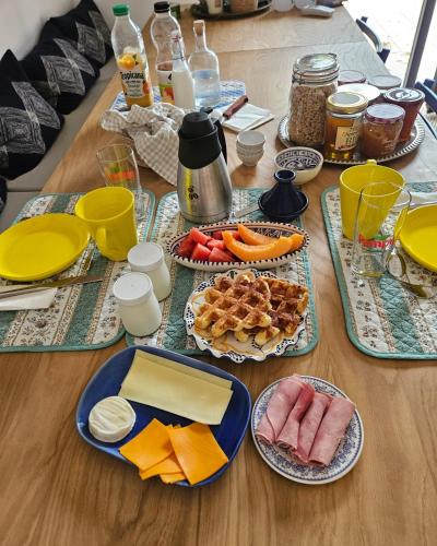 een houten tafel met borden met eten erop bij Les Cactus Bleus in Sausset-les-Pins