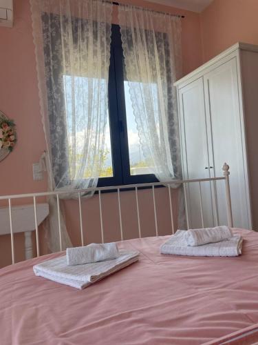 a bedroom with a pink bed with two pillows on it at Plaka Luxury Villa in Litochoro