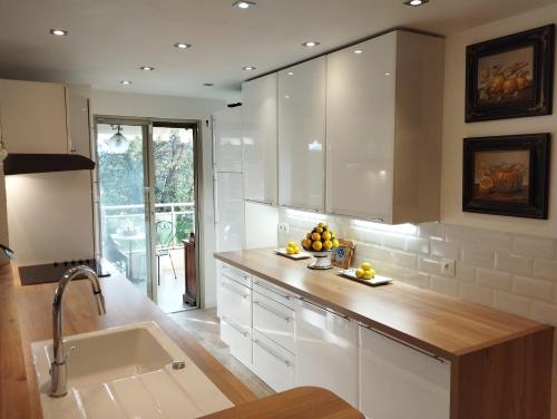 a kitchen with white cabinets and a sink at La Californie Views II in Cannes