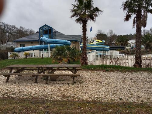 a park with a bench and a water slide at Mobile home SUPER CORDELIA CONFORT & FAMILIAL in Pont-Aven