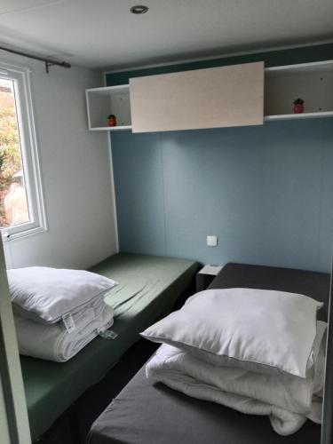 une petite chambre avec deux lits et une fenêtre dans l'établissement Mobile home SUPER CORDELIA CONFORT & FAMILIAL, à Pont-Aven