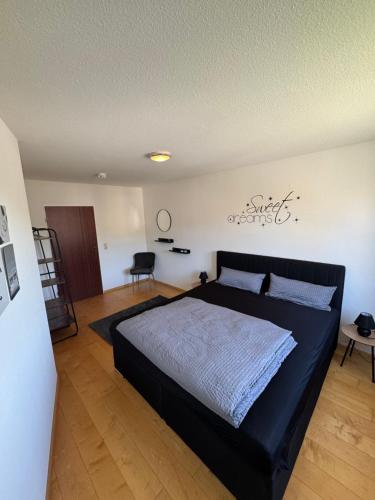 a bedroom with a large black bed in a room at Emelies Sonnenwohnung mit Balkon in Efringen-Kirchen