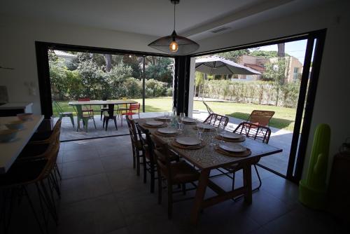 une salle à manger avec une table et des chaises et une grande fenêtre dans l'établissement Villa Les Pesquiers, à Hyères