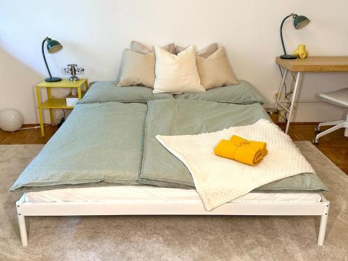 a white bed with a yellow pillow on it at Zentrale Wohnung mit Parkplatz in Graz