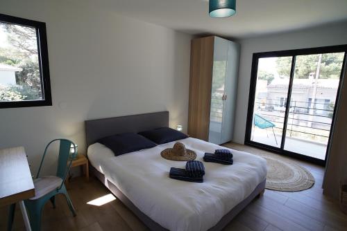 une chambre avec un lit avec un chapeau dessus dans l'établissement Villa Les Pesquiers, à Hyères