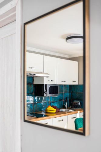 a kitchen with white cabinets and a mirror at Top Alex domki Międzyzdroje Lubin in Międzyzdroje