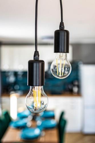 two light bulbs hanging from a kitchen table at Top Alex domki Międzyzdroje Lubin in Międzyzdroje