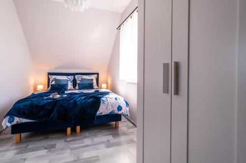a bedroom with a bed with a blue comforter at Top Alex domki Międzyzdroje Lubin in Międzyzdroje