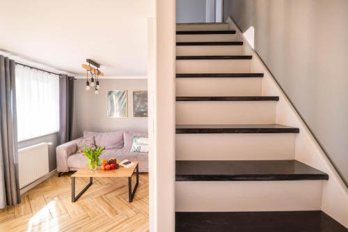 a staircase in a living room with a table at Top Alex domki Międzyzdroje Lubin in Międzyzdroje