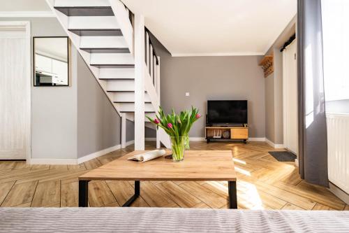 a living room with a table and a staircase at Top Alex domki Międzyzdroje Lubin in Międzyzdroje