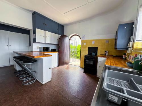 a kitchen with black and white cabinets and a counter at Hermanus Backpackers & Budget Accommodation in Hermanus
