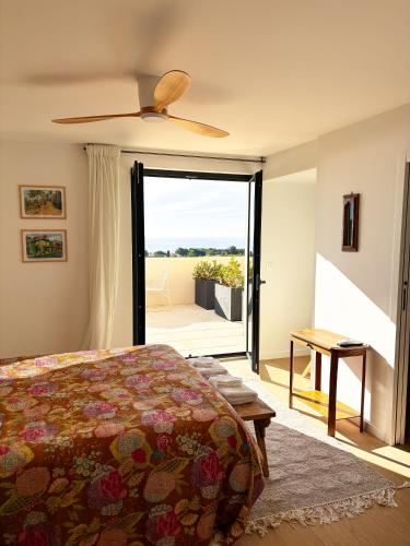 une chambre avec un lit et une porte coulissante en verre dans l'établissement Les Cactus Bleus, à Sausset-les-Pins