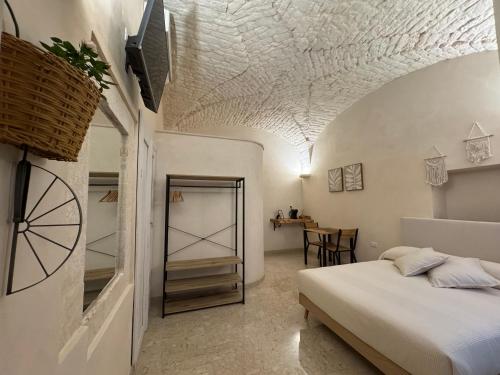 Un dormitorio con una cama y una mesa en una habitación. en Volta Meraviglia, en Martina Franca
