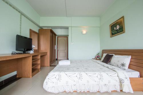 a bedroom with a bed and a flat screen tv at The Garden Place Bangkok in Nonthaburi