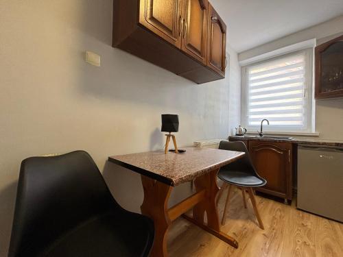 a small kitchen with a table and two chairs at Apartamenty nad Zatoką in Jastarnia