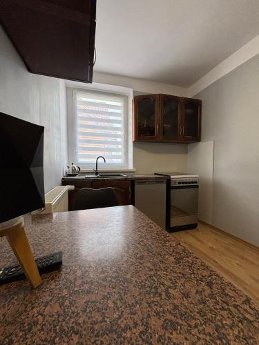 an empty kitchen with a table and a counter top at Apartamenty nad Zatoką in Jastarnia