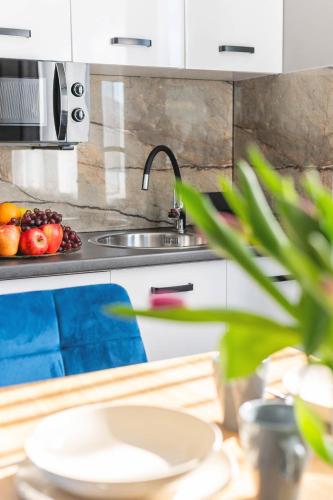a kitchen with a sink and a bowl of fruit at Top Alex domki Międzyzdroje Lubin in Międzyzdroje