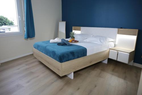 a bedroom with a bed with a blue wall at Cosy T3 Oiseau de Paradis Billard Balnéothérapie proche aéroport et centre-ville in Saint-Denis
