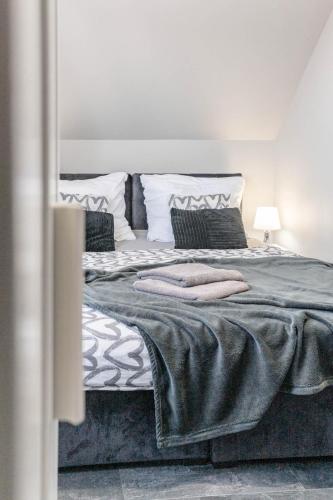 a bedroom with a large bed with two pillows at Top Alex domki Międzyzdroje Lubin in Międzyzdroje
