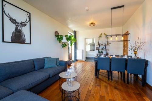 a living room with a blue couch and a table at Op de koule in Klimmen