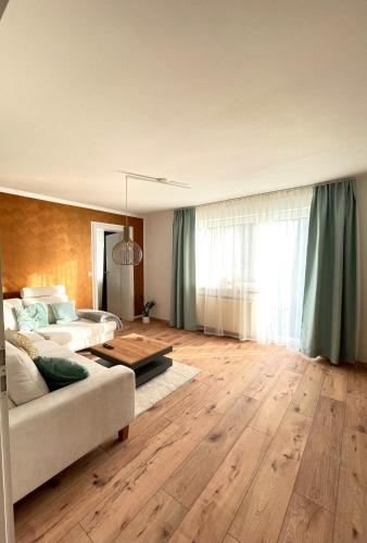 a living room with a couch and a table at Ferienwohnung Schwarzwaldnest im Heimbachtal in Loßburg