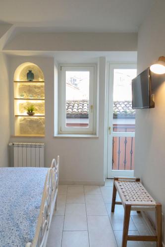 a white bedroom with a bed and two windows at Dimora Isabel in Tivoli