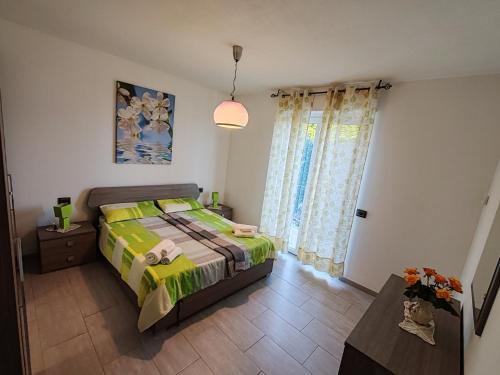 a bedroom with a bed with a green comforter at Villa Kira 2 in Verbania
