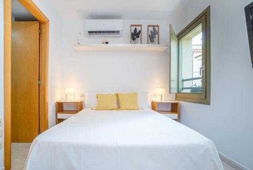 a bedroom with a white bed and a window at Milenial Immo Peralada 3A - Acogedor apartamento en el centro de Figueres, a unos pasos del museo Dalí in Figueres