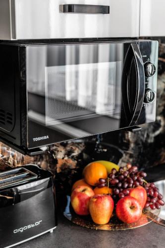 a plate of fruit in front of a microwave at Top Alex domki Międzyzdroje Lubin in Międzyzdroje