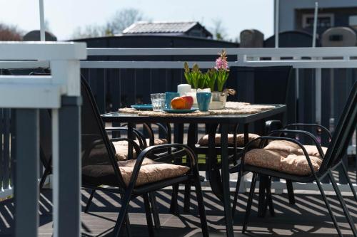 a table and chairs on a balcony with a meal on it at Top Alex domki Międzyzdroje Lubin in Międzyzdroje