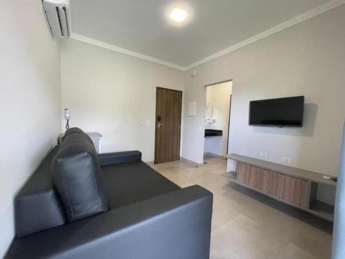 a living room with a couch and a flat screen tv at Grandes Lagos Thermas Resorts in Santa Clara dʼOeste