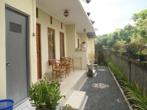 a house with a patio with chairs and a table at Sintya Homestay in Ubud