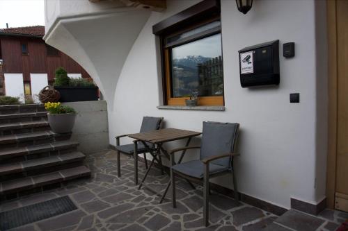 a table and chairs on a patio with a window at Wiesenblick Mils in Mils bei Hall