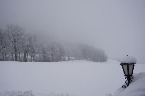 a street light covered in snow next to a lake at Wiesenblick Mils in Mils bei Hall