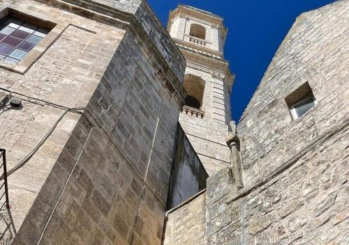 a building with a clock tower on top of it at Suite Dimora Antico Campanile in Locorotondo
