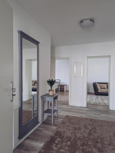 ein Wohnzimmer mit Spiegel und Tisch in der Unterkunft Ferienwohnung im Tal der Liebe in Schmelz